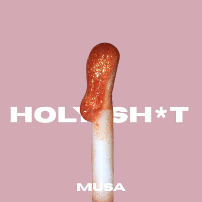 Soft and big applicator of a gold glitter lip oil from Musa. Glitter Makeup.